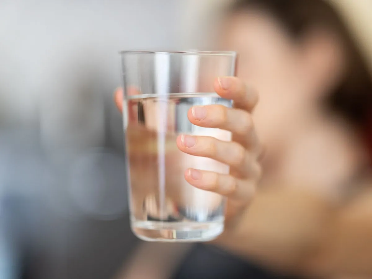 Hand som håller ett glas vatten